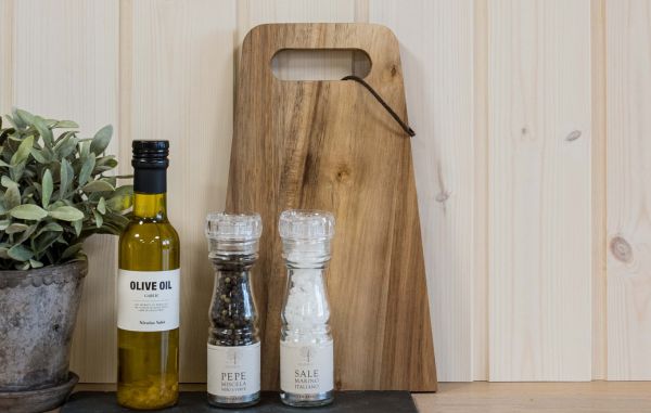 Trepanel skygge skrå i hvitlasert på kjøkken, med olivenolje og salt og pepper samt urter og skjærefjøl