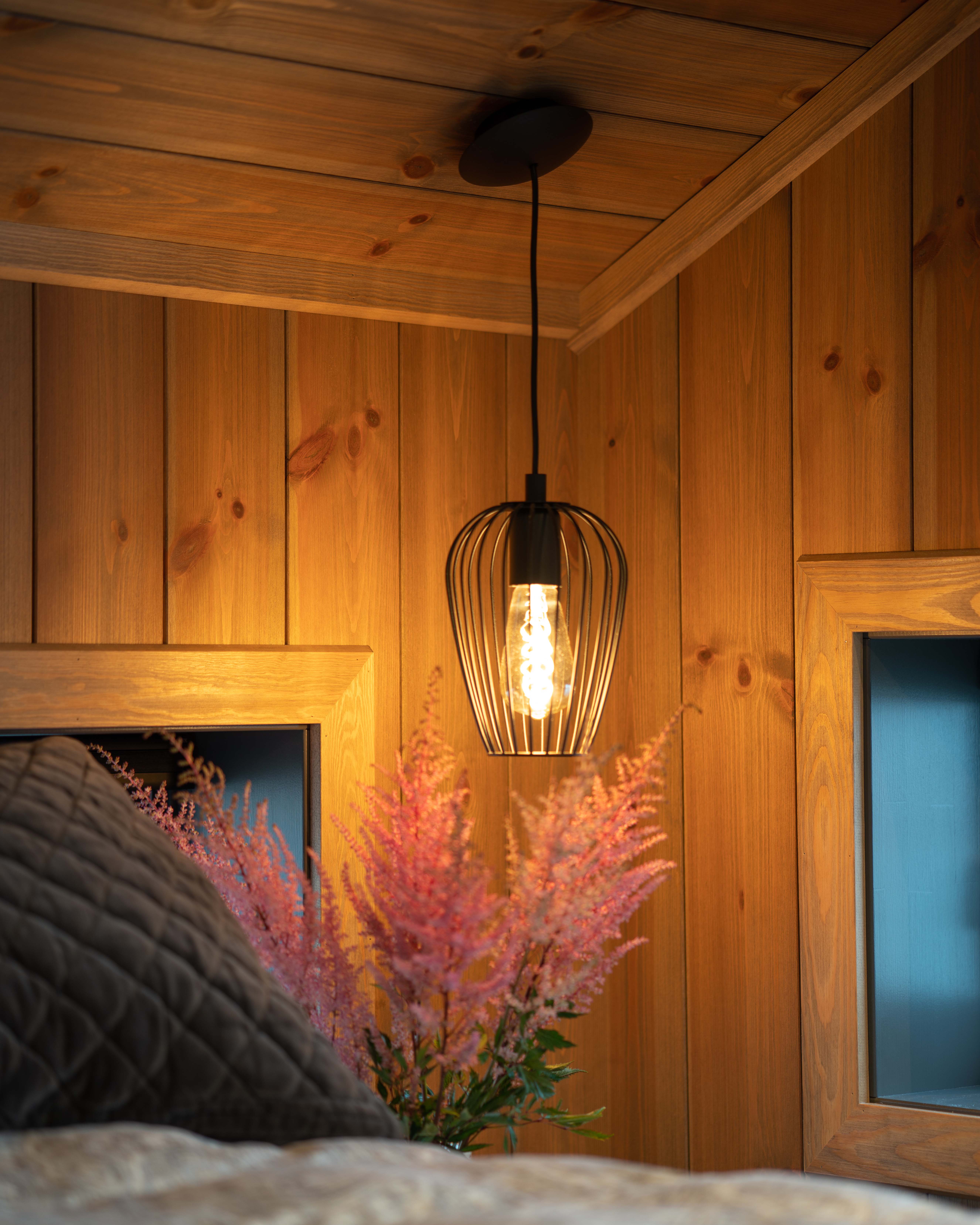 Moelven Sprekkpanel oljet Kongle på soveromsvegg med varm og lun trestruktur.