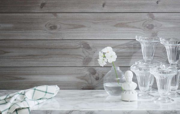 Trepanel Sjøbod Sten på kjøkken med marmor benkeplate. Glass og vase.